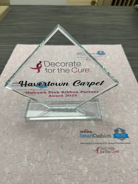 Award on top of SmartStrand pad. Award reads "Decorate for the Cure. Havertown Carpet. Mohawk Pink Ribbon Partner Award 2025".