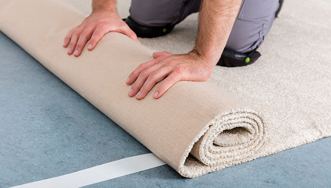 Worker's Hands Rolling Carpet | Havertown Carpet